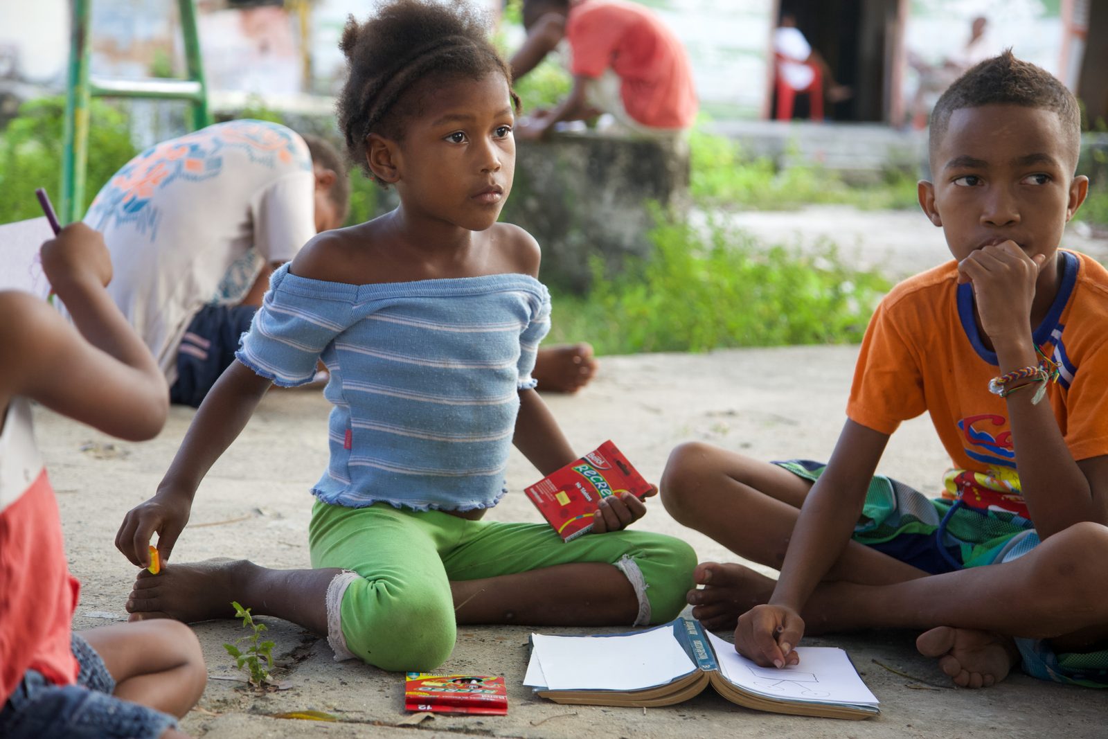 Children drawing on the ground in the shade, Barú